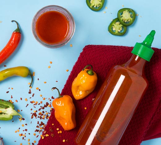 Image of hot sauce and different types of chilis