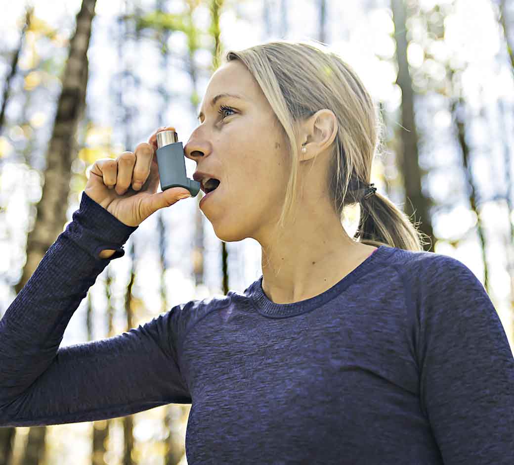 Woman with allergies using inhaler for asthma