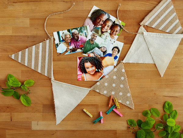 5x7 prints of family photos with canvas flag garland and colorful clothespins