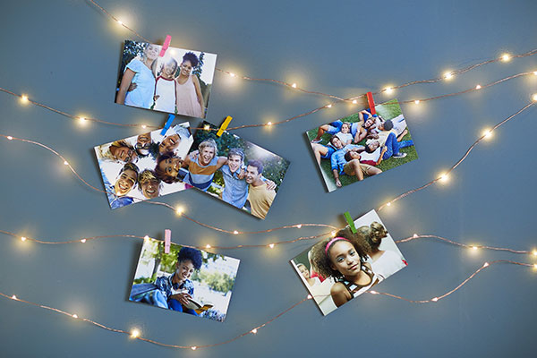 Finished photo garland with prints of teens clipped to the string lights