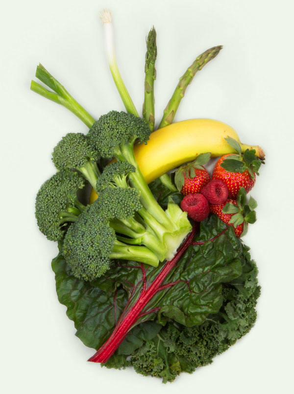 Broccoli, banana, berries, kale and asparagus in the shape of an anatomical heart
