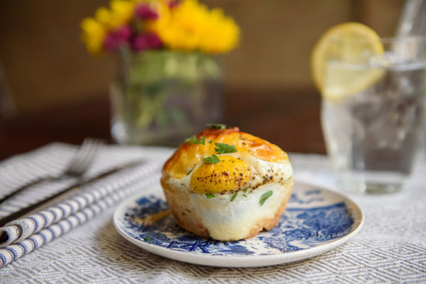 Egg biscuit at a place setting with flowers and lemon water