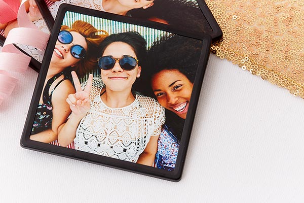 A photo magnet with a black framed as a gift to thank party guests