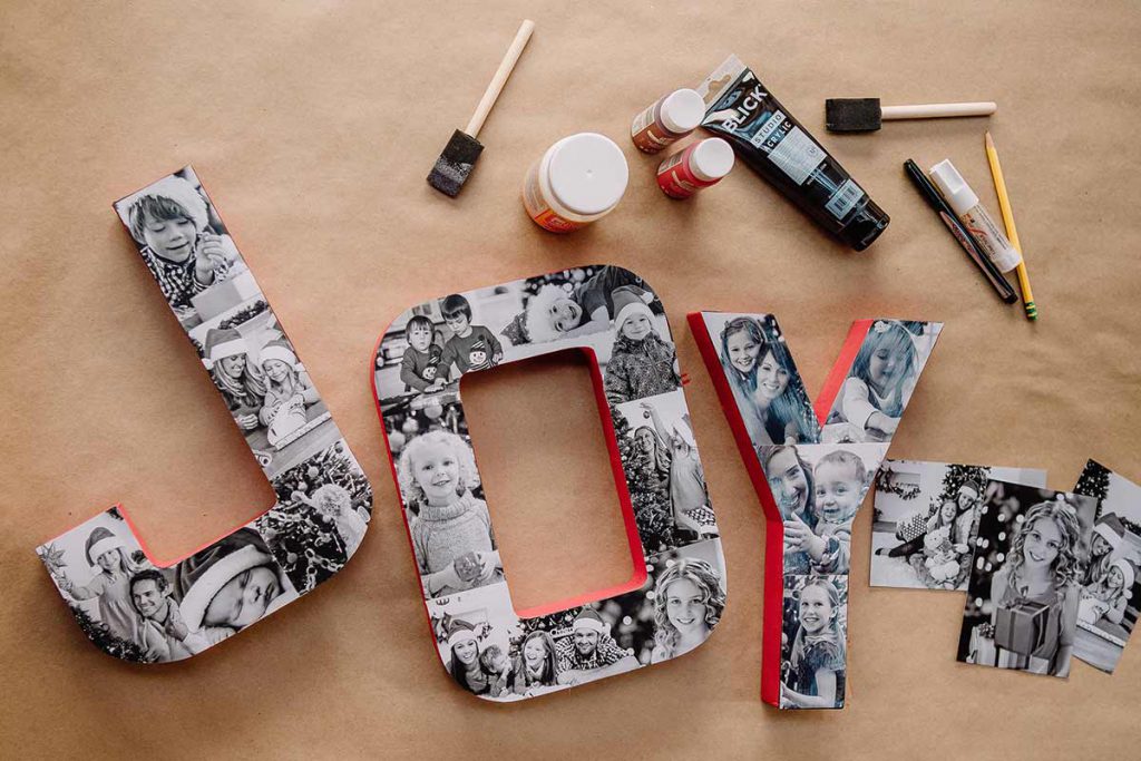 Block letters forming the word "Joy" decorated with a collage of black and white family photos
