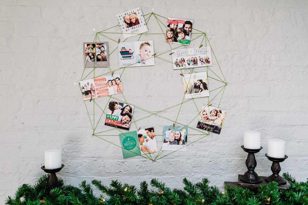 Decorative DIY card wreath with holiday photo cards clipped to string in the shape of an octagon