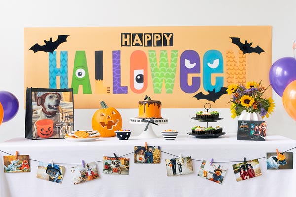 Table with festive Halloween decorations and a banner that says "Happy Halloween."