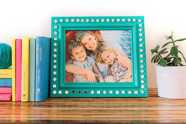 Finished Mother's Day custom frame with print of family photo displayed on bookshelf