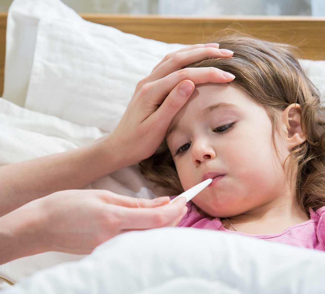 Toddler with flu getting temperature taken