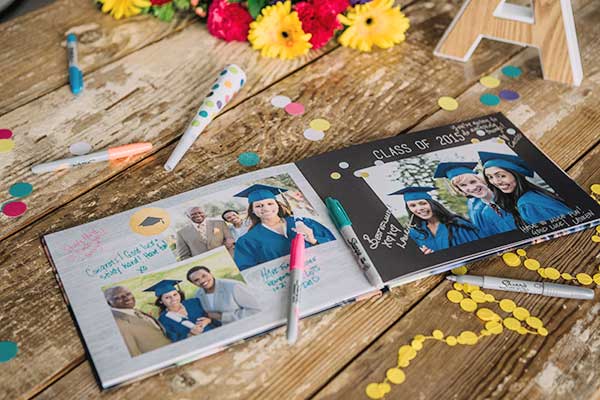 Graduation Photo Book displayed on a table with Sharpie markers for guests to sign at the graduation party